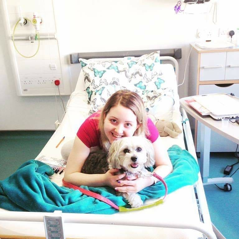 Alannah-Jayne Simpson in a hospital bed with her dog