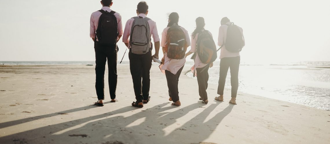 Group of friends walking on a beach